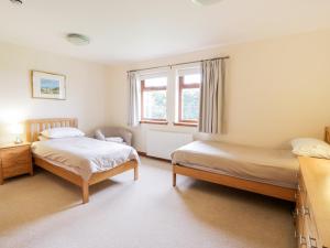 a bedroom with two beds and a window at Cairnhapple House in Stranraer