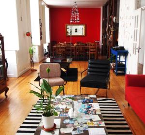ein Wohnzimmer mit einer roten Wand und einem Tisch in der Unterkunft Living Lounge Hostel in Lissabon