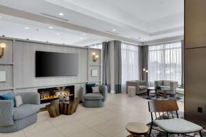 a living room with a fireplace and a tv at Hilton Garden Inn Toronto/Brampton in Brampton