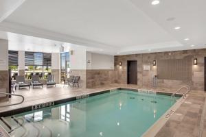 a swimming pool in a hotel lobby with a swimming pool at Hilton Garden Inn Toronto/Brampton in Brampton