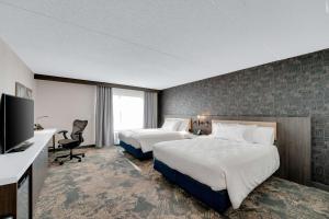 a hotel room with two beds and a flat screen tv at Hilton Garden Inn Toronto/Brampton in Brampton +37 photos