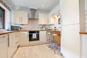 a kitchen with white cabinets and a refrigerator at 5 St Georges House Lovely 1-Bed Apartment Right in the Heart of York Pass the Keys in York