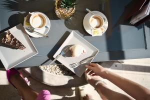 a person sitting at a table with a cake and coffee at BRISTOL Hotel Opatija in Opatija