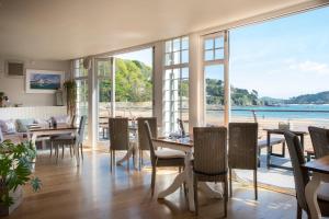 a dining room with tables and chairs and a large window at South Sands Hotel in Salcombe