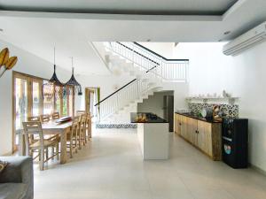 a kitchen and dining room with a table and a staircase at Kubu Ramah Seminyak 3BR and 2BR Private Pool Villas in Seminyak