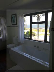 a bathroom with a large tub and a window at Point Lodge Knysna in Knysna