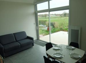 a living room with a table and a couch at GITE LA POISSONNIERE in Sevremont
