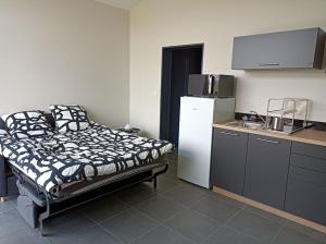 a kitchen with a bed and a refrigerator in a room at GITE LA POISSONNIERE in Sevremont