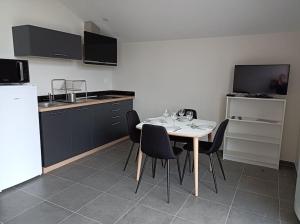 a kitchen with a table with wine glasses on it at GITE LA POISSONNIERE in Sevremont +1 photo