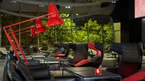 un restaurant avec des lumières rouges, des chaises et des tables dans l'établissement Park Plaza London Riverbank, à Londres