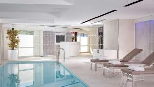 a bathroom with a swimming pool and chairs at Park Plaza London Riverbank in London