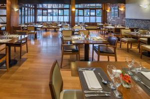 a restaurant with wooden tables and chairs and tables and chairsktop at NH Bariloche Edelweiss in San Carlos de Bariloche