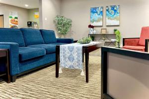 a living room with a blue couch and a table at Quality Inn & Suites Wisconsin Dells Downtown - Waterparks Area in Wisconsin Dells