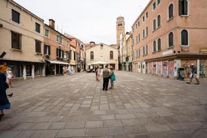 a group of people walking down a city street at San Polo Studio in Venice
