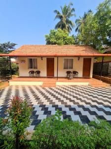 una casa con un ampio patio con tavoli e sedie di Sunny Smiles a Mangalore