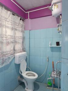 a bathroom with a toilet and a shower curtain at Wonder Hill Parivaar homestay in Darjeeling