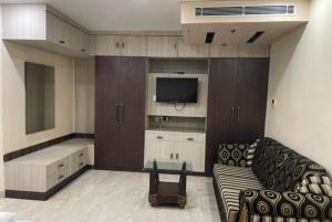 a living room with a couch and a tv at Goroomgo Padoshi Near Sea Beach Puri - Spacious Room 100 Meters From Sea Beach in Puri