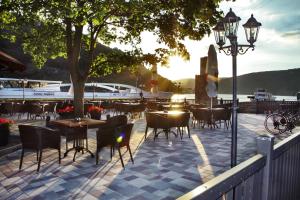 a patio with tables and chairs and a street light at Hotel Rheinkönig in Kamp-Bornhofen