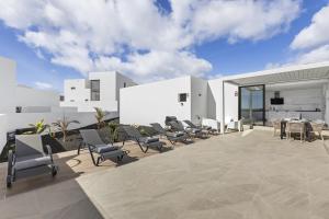 a patio with a bunch of chairs and a table at Casahost Fontaine Bleue Villa in Tías