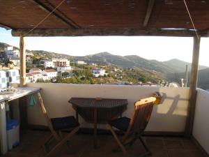 einen Tisch und zwei Stühle auf einem Balkon mit Aussicht in der Unterkunft Beautifully renovated village house with spectacular views in Canillas de Albaida