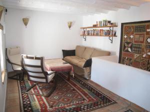 ein Wohnzimmer mit einem Sofa und einem Stuhl in der Unterkunft Beautifully renovated village house with spectacular views in Canillas de Albaida