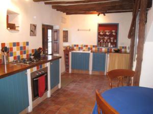 eine Küche mit blauen Schränken und einem Tisch im Zimmer in der Unterkunft Beautifully renovated village house with spectacular views in Canillas de Albaida