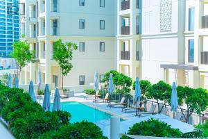 uma imagem de uma piscina do hotel com guarda-sóis e cadeiras em Supreme Luxury 2BR Apartment em Dubai