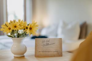 une carte assise à côté d'un vase avec des fleurs jaunes dans l'établissement Käferberghof, 