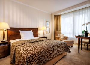 a hotel room with a bed and a chair and a desk at Hotel Nassauer Hof in Wiesbaden