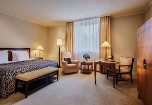 a hotel room with a bed and a desk and chair at Hotel Nassauer Hof in Wiesbaden