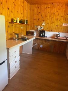 a kitchen with wooden walls and a white counter top at Hoopoe log cabin in Albert Falls