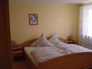 1 cama con almohadas en el dormitorio en Ferienhof Roller, en Simmersfeld
