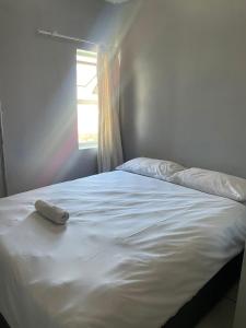 a white bed in a room with a window at Stay Inn Lodge Boksburg in Boksburg