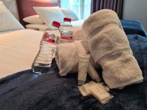 a towel and two bottles of water on a bed at Jackson Court Hotel in Dublin