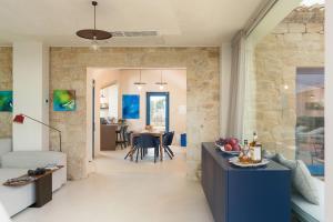 a living room and dining room with a stone wall at Al Nair in Marina di Modica