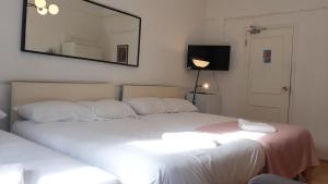 twee bedden in een kamer met een spiegel aan de muur bij King garden hotel in Londen