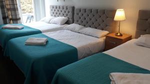 King garden hotel في لندن: غرفة نوم بسريرين ذات شراشف زرقاء وبيضاء
