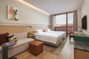 um quarto de hotel com uma cama e um sofá em Hyatt Place Jingdezhen Taoxichuan em Jingdezhen