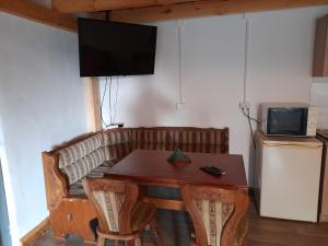 uma sala de jantar com uma mesa e uma televisão na parede em Alpaka-Ranczo AFF em Puławy