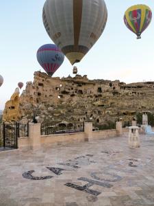 dos globos de aire caliente volando sobre un edificio de piedra en Canela Cave Hotel - Cappadocia, en Göreme