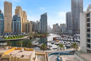a view of a city with boats in a harbor at Cozy Dubai Marina Design Studio close to Jumeirah Beach, Mall & Metro in Dubai