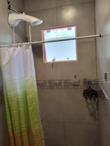 cortina de ducha en un baño con ventana en Pousada Morretes Arraial, en Morretes