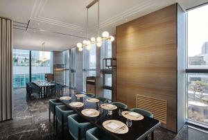 a dining room with a long table and chairs at Wyndham Grand Busan in Busan