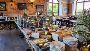 a buffet of food on a table in a restaurant at Folwark Łękuk in Łękuk Mały