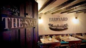 a restaurant with two tables and a sign on the wall at Farmyard Inn in Youlgreave