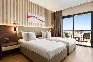 Postel nebo postele na pokoji v ubytování Ramada by Wyndham Cesme