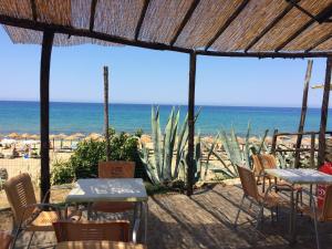 a patio with tables and chairs and the beach at Villaggio Silvia in Castellabate