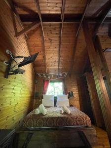 um quarto com uma cama num chalé de madeira em Itamar Cabins em Had Nes