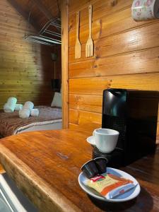 eine Holztheke mit einer Mikrowelle und einer Schüssel darauf in der Unterkunft Itamar Cabins in Had Nes