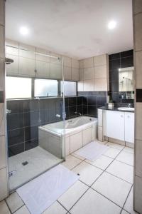 a bathroom with a shower and a bath tub at Stay at The Point - Magnificent Magical Marvel in Durban